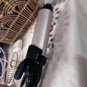 BaByliss Locktång - BaByliss locktång med justerbar temperatur och keramisk beläggning. Svart och silver design, synligt i gott skick utan tydliga repor eller skador.