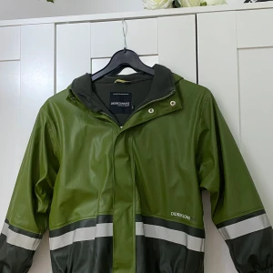 Grön regnjacka från Didriksons 1913 - Allt är som i bilden och jag är helt säker att den inte har fläckar eller skador, eller vad tycker ni? Regnjackan är för barn i storleken 130. Meddela mig gärna om ni vill veta mer! 💕