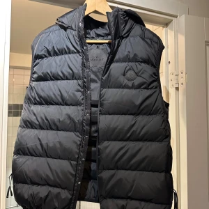Svart dunväst från Moncler med huva - Size 3 hör av dig vid intresse.