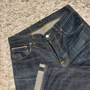 Dry Selvedge nudie jeans grim trim slim fit herr  - Dry selvedge nudie jeans modell grim trim i slim striaght passform. Nytt skick inga defekter, riktigt najs material. W29 passar 30 också, 100% organic cotton. Postas antigen samma dag som köp eller dagen därpå🙌💯