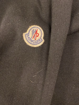 Svart Moncler pufferjacka L - Säljer en svart cardigan från Moncler i storlek L. Moncler-logga på ärmen. Materialmix med stickad kropp och syntet på puffpartierna. Perfekt för dig som vill ha en skön cardigan. Priset kan diskuteras, vet inte om den är äkta