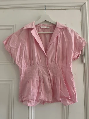 Rosa skjortliknande blus från Zara - Säljer denna superfina rosa topp som är perfekt inför vår/ sommar. Den drar in perfekt i midjan och gör en så snatched. Tveka inte på att höra av dig om du har frågor❤️