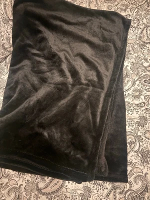 Svart filt - Mjuk och fluffig svart filt i syntetmaterial. Filten har en enkel och stilren design utan synliga detaljer. Perfekt för dig som gillar att hålla värmen.