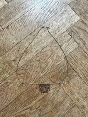 Snyggt halsband med monogram i silver - Kedja i silverfärg med ett dekorativt monogram som hänge. Halsbandet är ca 48 cm långt och har en tunn, elegant kedja. Perfekt accessoar för att lyfta din outfit med en personlig touch.