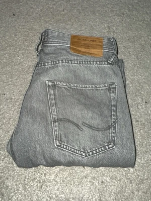 Grå jeans från Jack & Jones, 28/30 - Säljer ett par skit fina grå jeans från Jack & Jones i storlek 28/30. Dem ser i stort sett helt nya ut! Skickar dem även snabbt!!:)