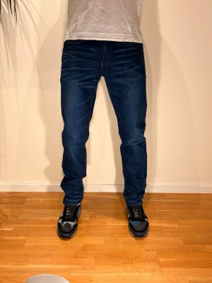 G-star Jeans - Passform 🔥Vill du ha på dig det tjejer önska killar hade istället för alla dessa slimmade jeans? Då är dessa jeans perfekta för dig! Dessa är otroligt snygga och är i strl 28/32, passar även uppåt. Modell på bilden är 184 och väger Ca 70 kg. Vid minsta lilla fundering tveka absolut inte på att höra av er till oss! /N&V 🤝 