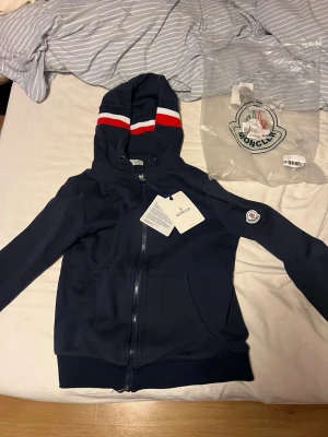Moncler hoodie - Sjukt fett tröja med luva från Moncler. Passar alla olika stiler, är väldigt varm och mjuk!