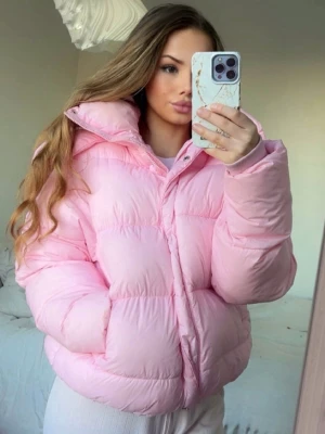 Bik Bok Jacka 🩷 - Säljer en populär rosa pufferjacka från BikBok i storlek XS. Jackan har huva, dragkedja och knappar framtill samt ribbade muddar vid ärmslut. Perfekt för kalla dagar och har en riktigt mysig vibe. Har några fläckar här och var 🩷