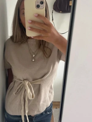 Beige stickad tröja med knytband Zara - Superfin beige stickad tröja med korta ärmar! Inga defekter alls! Så snygg storlek M men mer som en S