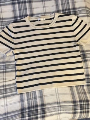 Stickad T-shirt - Säljer denna snygga randiga topp från Gina Tricot som tyvärr är för liten för mig.💕Toppen är perfekt för varma sommardagar och till ett par linnebyxor💕☀️. Skriv för frågor eller mer bilder💕