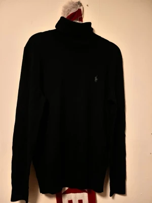 Svart Kashmir polotröja från Ralph Lauren - Svart kashmir polotröja från Ralph lauren. Använd 1-2 gånger och är helt nyskick. inga tecken på slitage eller defekter & användning! 