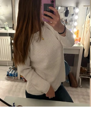 Vit stickad tröja med rund hals - Säljer en enkel och stilren vit stickad tröja med rund halsringning. Tröjan har lång ärm och en klassisk, lite loose passform. Perfekt att slänga på sig till jeans eller kjol för en chill look.