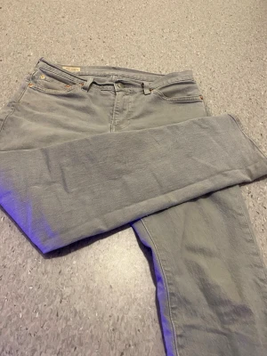 Levi's 511 ljusgrå jeans - Säljer ett par ljusgrå Levi's 511 jeans med klassisk femficksdesign och raka ben. Jeansen har en snygg, enkel look och är tillverkade i mjukt bomullsmaterial. Passar perfekt till en avslappnad stil och har den ikoniska Levi's-lappen bak.