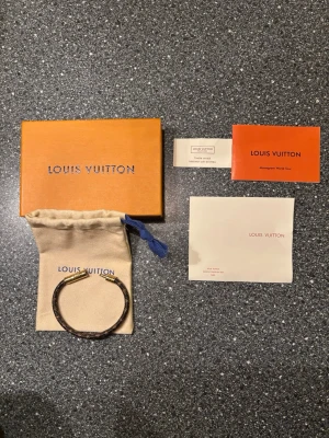 Louis Vuitton armband - 💎 Louis Vuitton armband – komplett originalset 💎  Säljer ett exklusivt Louis Vuitton-armband i mycket fint skick. Ett tidlöst och stilrent armband med det klassiska LV-monogrammet och guldfärgad låsdetalj.  ✔ Mycket bra skick ✔ Väl omhändertaget ✔ Original ask, dustbag och papper ingår ✔ Se bilder  Perfekt accessoar som lyfter vilken outfit som helst och passar både till vardag och finare tillfällen.  📩 Skriv vid intresse, frågor eller om du vill ha fler bilder. Priset kan diskuteras.