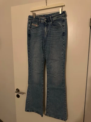 Blå bootcut jeans från Diesel - Säljer ett par klassiska blå jeans från Diesel i bootcut-modell. Jeansen har fem fickor, normal passform och är tillverkade i slitstarkt denimtyg. Nypris 1800kr 