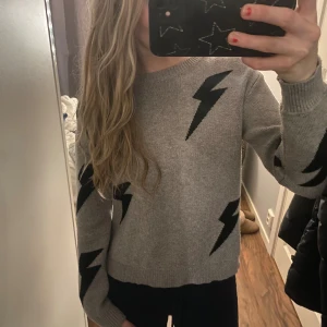 Grå stickad tröja med blixtar - En jätte bekväm och stilig stickad tröja, det är storlek S men passar både XS/S. Hör av er vid frågor!