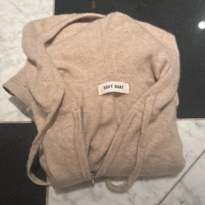 Soft goat zip - Mysig beige hoodie från Soft Goat i Kashmir. Jättefin och hade gärna haft kvar den, men är för liten för mig. Nypris: 2695kr. Använd ca 2 gånger skulle jag gissa och vill gärna köpa ny därför säljer jag för 1500kr.