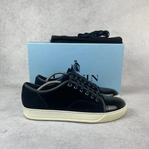 LANVIN DBB1 CAP TOE SNEAKER - – Condition: 9/10  - Size: 41/UK7  – What is included: Dustbag  – Retail price: 5000 + SEK  Please note that Lanvins fit big and our recommendation is to go one size down