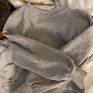 Grå långärmad tröja från Gina Tricot - Mysig grå långärmad tröja från Gina Tricot i storlek XXS. Tröjan har en enkel rund halsringning med puffiga ärmar och är gjord i ett mjukt, stickat material som passar perfekt för kyligare dagar. Pris går alltid att diskutera!!🤍