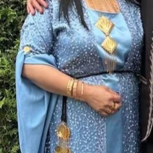 Ljusblå lawandi med glitterdetaljer - Ljusblå kurdisk klänning (lawandi) med glittriga broderier. Klänningen har vida, långa ärmar och ett elegant fall. Perfekt för speciella tillfällen. Smycken ej ingår. 