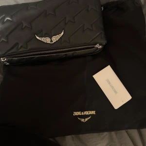 Svart axelväska från Zadig & Voltaire - Snygg svart axelväska från Zadig & Voltaire i skinn med quiltat stjärnmönster. Två olika kedjor tillkommer (en kortare och en längre) som går att ta av och på. Väskan är köpt från Zadig & Voltaire’s hemsida vintern 2021, nypris ca 3800kr. Pris är diskuterbart☺️