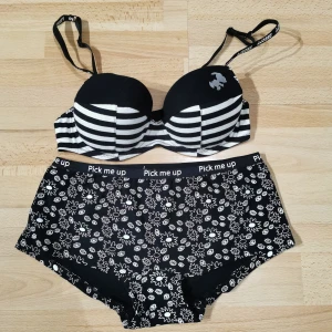  Snoopy BH och hipster  - Svartvit BH från Snoopy med coola ränder och en liten Snoopy-figur på ena kupan. Axelbanden är justerbara och har Snoopy-tryck. Perfekt för dig som gillar lekfulla detaljer och kontrasterande färger.