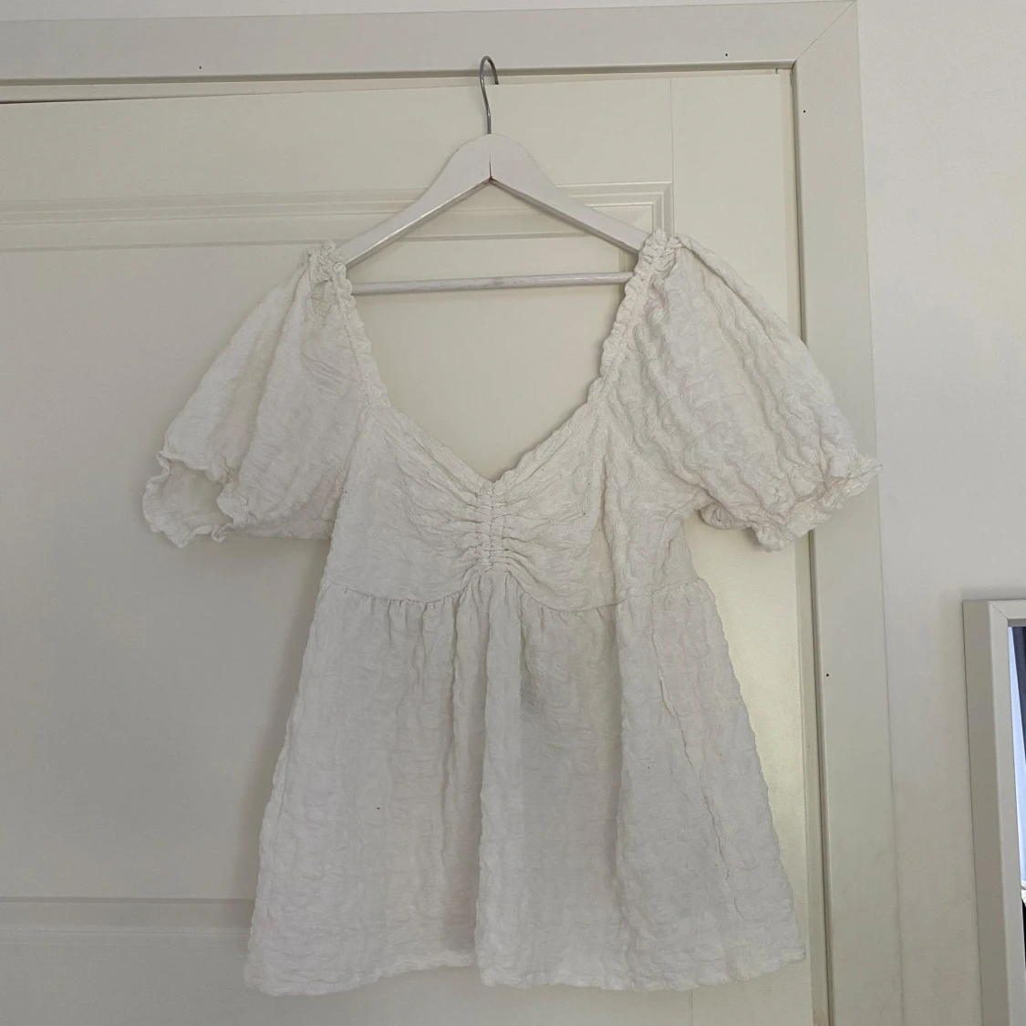 Vit blus med puffärmar och v-ringning