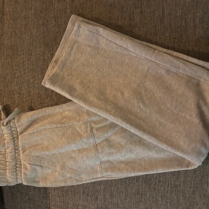 Beiga mjukisbyxor med resårmidja S - Beiga mjukisbyxor i storlek S med bred resår i midjan och dragsko. Byxorna har raka ben och stora sidofickor, perfekta för en chill och avslappnad stil. Tillverkade i mjukt material som känns skönt mot huden.