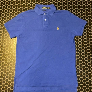 Blå pikétröja från Polo Ralph Lauren👕 - Polotröja Ralph Lauren 👕 249kr Ljusblå polotröja från Ralph Lauren med den ikoniska logotypen på bröstet. Skjortan är i gott skick med mindre tecken på slitage.  ⭐️ Skick: 9/10  🎲 Storlek: M 🎨 Färg: Mörkblå 📦 Snabb och noggrann leverans 🙋‍♂️bara höra av er vid frågor/funderingar🙋‍♂️