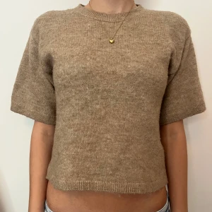 Beige stickad tröja från H&M - Beige stickad tröja från H&M med korta ärmar. Storlek xxs men skulle säga att den passar xs också💕 (OBS köparen står för frakten)