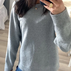 Grå stickad tröja från Vero Moda - Mysig grå stickad tröja från Vero Moda med ribbade muddar vid ärmslut och nederkant. Perfekt för lager-på-lager och enkel att matcha.💞💞