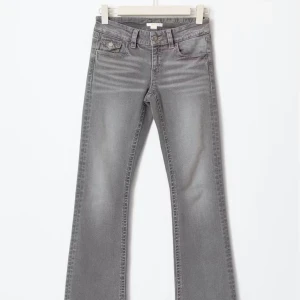 Grå bootcut jeans med fickdetaljer - Jättefina gråa jeans från gina tricot, modellen heter ”chunky low flare jeans” de är i storlek 158. säljer då de inte kommer till användning. skriv för fler bilder eller frågor!!💕