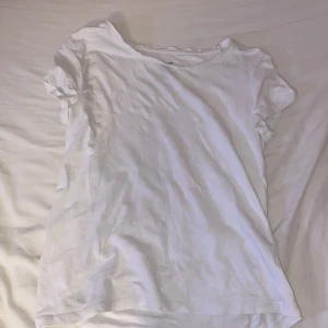 Vit basic t-shirt från H&M - Enkel vit t-shirt från H&M i ekologisk bomull. Klassisk rund halsringning och korta ärmar. Perfekt basic-plagg med normal passform, lätt att matcha till allt.