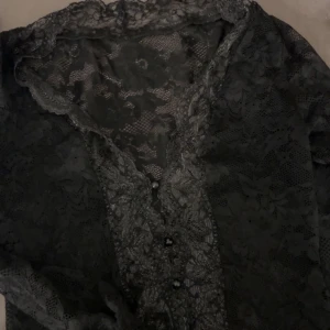 Svart spetsblus med knappar - Säljer då den inte används 