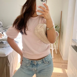 Ljusrosa topp med puffärm  - Supersöt ljusrosa stickad topp med korta puffärmar och rund hals. Mjuk och skön, perfekt till jeans eller kjol. Enkel och stilren design som ger en gullig vibe.