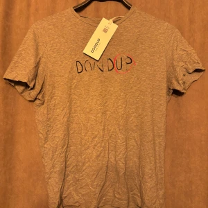 Dondup T-Shirt - Säljer denna snygga dondup T-Shirt med ett elegant tryck. Skick=7/10 Ny pris=1799kr och mitt pris är endast 499kr// Allt gott