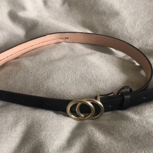 Skärp - Svart skärp från H&M. Använd! Lite rostig. Tio hål.