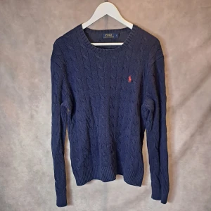 Marinblå Ralph Lauren Tröja - Stl L - Väldigt snygg Kabelstickad Tröja från Ralph Lauren! Mycket bra skick: 8,5/10, lätt spår av användning | Stl L | Modellen på bilden är 175cm lång, men passar dig bäst mellan 180-190cm |
