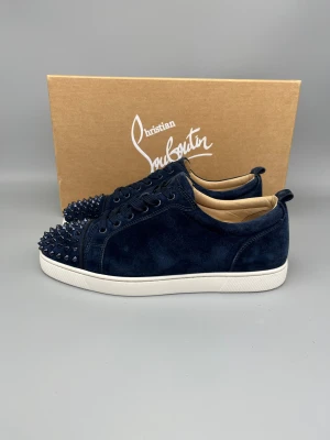 Christian Louboutin Louis Junior Spikes Sneaker Navy - • The shoes have only been worn a few times and are in like-new condition  • Size: 43 (fits 43.5–44)  • Color: Navy / Dark Blue  • Retail price: 9500 SEK / 795€  • Box included