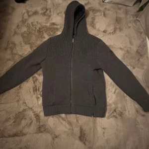 Fin stickad kofta  - Väldigt fint skick utöver att det är ett hål inuti jackan i armen som ej syns och går att sy igen hemma. En perfekt kofta att ha nu till vintern eftersom att det är jack material inuti. Hör av dig vid frågor eller intresse.