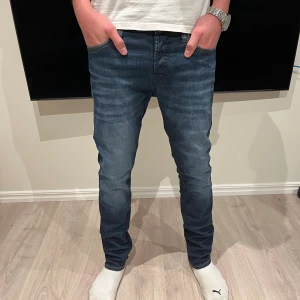 Mörkblå jeans från Jack & Jones - Snygga mörkblå jeans från Jack & Jones med klassisk femficksdesign och kontrastsömmar. Storlek W28 L32. Modellen är slim fit med lätt tvättade detaljer på låren och knäna. Skriv vid funderingar!✅