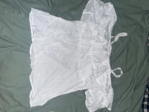 Vit offshoulder blus från Stories - Säljer en söt vit offshoulder blus från Stories i storlek M. Blusen har korta puffärmar, smockad resår upptill och knytband på axlarna. Perfekt för en fräsch och somrig look med luftig känsla.