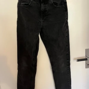 Svarta Lee jeans med smal passform - Snygga svarta jeans från Lee med klassisk femficksdesign och smal passform. Jeansen har Lee-logga på bakfickan och metallknapp framtill. Tillverkade i mjukt jeanstyg. Barnstorlek 12-13 Y