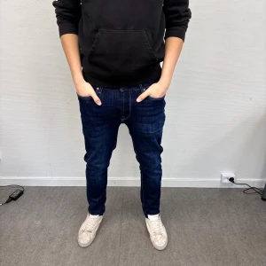 Mörkblå slim jeans från Dressman - Snygga mörkblå jeans från Dressman med klassisk femficksdesign och kontrastsömmar. Jeansen har en slim passform och raka ben. Tillverkade i slitstarkt denim/bomullstyg med lätt tvättade detaljer för en modern känsla. Perfekt för dig som vill ha en clean och stilren look!