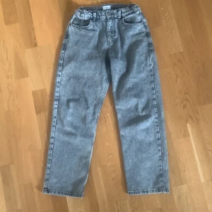 Grå jeans från Grunt, storlek 25 - Säljer ett par grå jeans från Grunt i klassisk femficksmodell. Jeansen har rak passform och normal midja, tillverkade i slitstarkt bomullsmaterial. Perfekt för dig som gillar en enkel och clean look med lite retrovibe. Modellen heter Hamon Ash Grey. Byxorna är köpta på Kidsbrandstore för 800kr