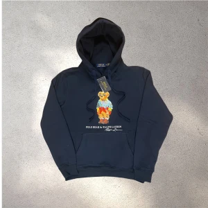 Mörkblå Polo Bear hoodie från Ralph Lauren - Snygg mörkblå hoodie från Ralph Lauren med Polo Bear-tryck på bröstet. Mycket bra skick. Inga hål, fläckar eller liknande.✅ skickar snabbt efter att du har beställt📦