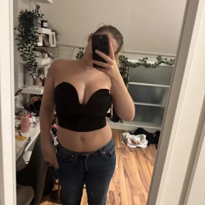 Svart croppad tubtopp med sweetheart-ringning - Säljer en svart croppad tubtopp med snygg sweetheart-ringning framtill. Toppen är axelbandslös och har en tight passform som framhäver midjan. Perfekt för dig som gillar en stilren och trendig look. Materialet känns mjukt och följsamt mot huden.