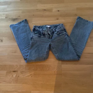 Grå jeans från Gina Tricot, storlek 170 - Snygga grå jeans från Gina Tricot i rak modell med klassiska fem fickor och bälteshällor. Jeansen har en normal passform och är tillverkade i slitstarkt denimtyg. Perfekta för dig som gillar enkel och stilren look.