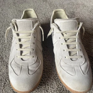 Maison Margiela vita sneakers i mocka - Maison Margiela, självklart äkta. De är storlek 44 men SITTER SOM 43or. Priset är inte hugget i sten och hör järna av dig om du har frågor. 😁