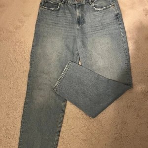 Ljusblå raka jeans från Vero Moda - Ljusblå jeans från Vero Moda med klassisk femficksmodell och raka ben. Jeansen har hög midja och är tillverkade i bomullsdenim. Perfekta för en avslappnad och trendig look. Använda en gång, men var inte riktigt min stil, så det är inget fel på byxorna. 